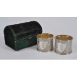 A pair of Victorian silver napkin rings, of typical circular form, repousse decorated all over and