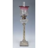 A Victorian silver plated oil lamp, having an acid etched cranberry tinted glass shade and cut glass