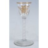 A circa 1770 wine glass, the pointed round funnel bowl gilt decorated with festoons above a double