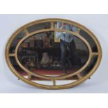 A late 19th century giltwood and gesso oval wall mirror, the bevelled plate within a sectional