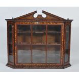 An 18th century Dutch walnut and floral marquetry inlaid cabinet, the glazed door enclosing three