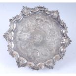 A George II silver salver, of shaped scrolling circular form and standing on three hoof feet, the