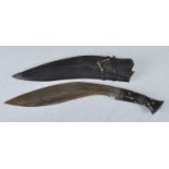 A 20th century kukri, having a typical 35cm curved fullered blade with brass mounted horn grip,