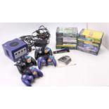 A Nintendo Gamecube console with an instruction leaflet, cables, two official controllers and two