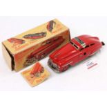 Schuco No. FEX1111 tinplate and clockwork model of a saloon, finished in red with red hubs and