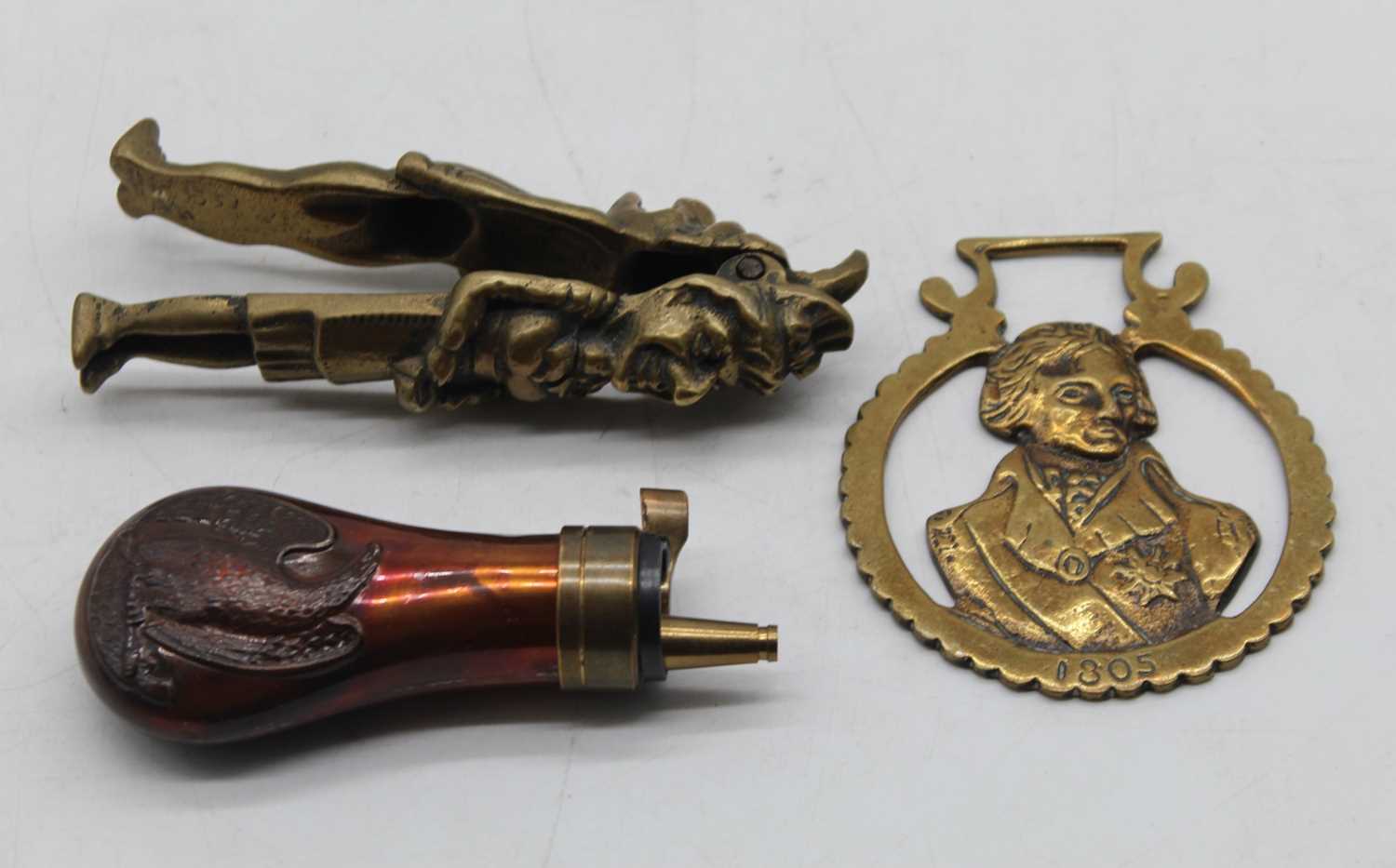 A repousse decorated copper powder flask; together with a brass Punch & Judy nutcracker; and a