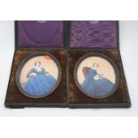 A pair of early 20th century overpainted portrait photographs, each 18 x 14cm