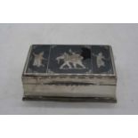 A sterling silver table cigarette box, decorated with eastern figures and an elephant, w.10cm