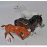 A Beswick model of a Shetland Pony, No.1033, brown gloss, h.15cm; together with two othersAll in