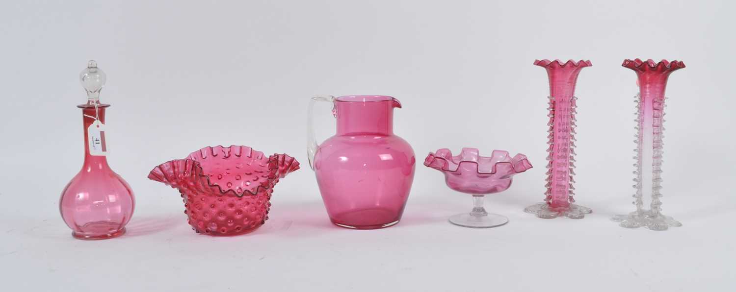 A collection of Victorian cranberry glassware, to include a water jug and decanter, the largest h.