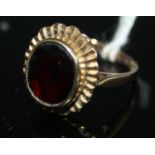 A 9ct gold and almandine garnet set dress ring, the oval cut garnet measuring approx 11 x 9.5 x 4mm,