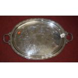 A silver plated twin handled serving tray, decorated with anthemion and scrolls within a beaded