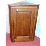 A 19th century provincial joined oak single door hanging corner cupboard