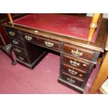 An Edwardian mahogany and rexine inset twin pedestal writing desk, having typical arrangement of