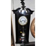 An early 20th century ebonised drop trunk wall clock, having pendulum and winding key, height 82cm