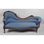 A Victorian faded mahogany framed spoon-end settee, having a swept frame and upholstered in a