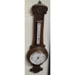 An early 20th century floral relief carved oak aneroid two-dial wheel barometer, height 91cm
