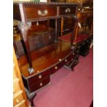 An early 20th century mahogany kneehole dressing table, having gadrooned edge with an arrangement of