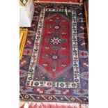A Persian woollen Shiraz red ground rug, 185 x 120cm