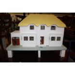 A Triang two-storey dolls house, white painted with yellow painted roof, raised on integral base,