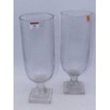 A pair of modern cut glass storm lamps, each having a fluted body on stepped square base, height