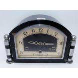 An Art Deco mantel clock, having ebonised and chrome mounted case, the arched dial with Arabic