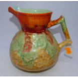 An Art Deco Clarice Cliff Bizarre Nuage jug, decorated in shades of orange, green and yellow, having