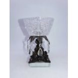 A table centrepiece, the cut glass bowl raised on a copper alloy flower head and scrolling column