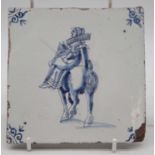 An late 18th / early 19th century Dutch Delft tile, underglaze blue decorated with a female riding