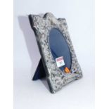 A modern Carrs of Sheffield silver clad easel photo frame of shaped rectangular form, repoussee