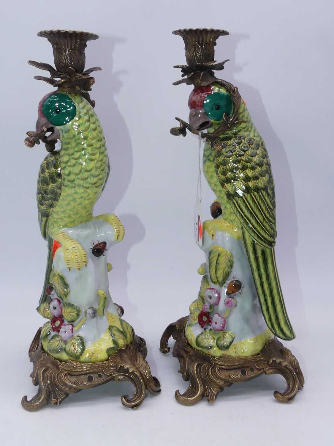 A pair of modern reproduction continental porcelain candlesticks each in the form of a parrot on a