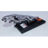 A reproduction Jaguar car mascot on marble plinth