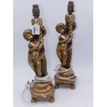 A pair of reproduction gilt figural candlesticks, each in the form of a cherub, height 46cm