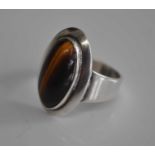 A Danish Sterling silver dress ring, set with a cabochon cut tiger's eye, marked NE Froms 925 S