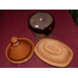 A glazed earthenware tagine dish and cover; together with a terracotta baking dish and cover; and