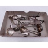 A collection of various silver and plated wares to include teaspoons, sifting spoon, sauce ladle