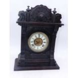 A late 19th century American walnut cased mantel clock, having an enamelled chapter ring with