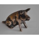 A late 20th century silver figure of a seated pig, maker Douglas Pell, London 1993, h.2cm, 0.6oz