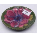 A Moorcroft pin dish, having tube-lined pink flower on green ground, with incised Moorcroft Made