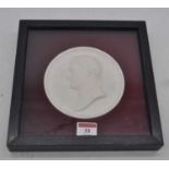 A plaster roundel depicting Emperor Napoleon, dia. 14cm, housed within a black ash frame