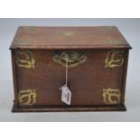 An early 20th century brass mounted oak stationery cabinet, the fall lifting to reveal an