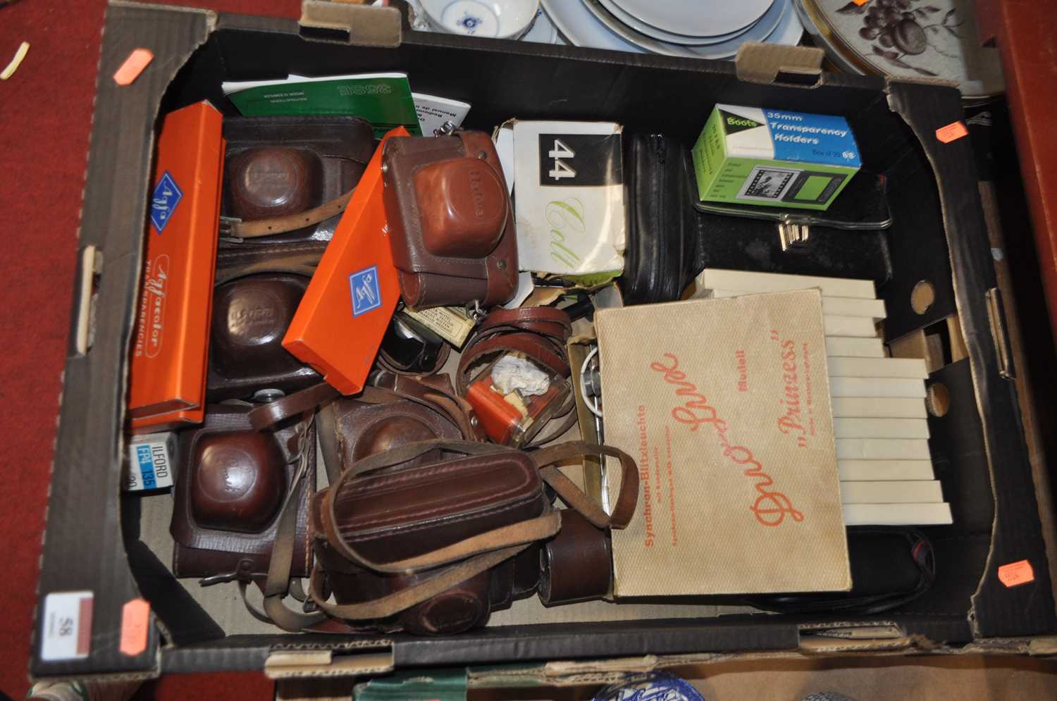 A box containing a collection of photography equipment to include vintage cameras, Halina, Ilford,