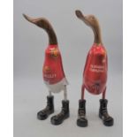 Two carved wooden model of ducks in football shirts