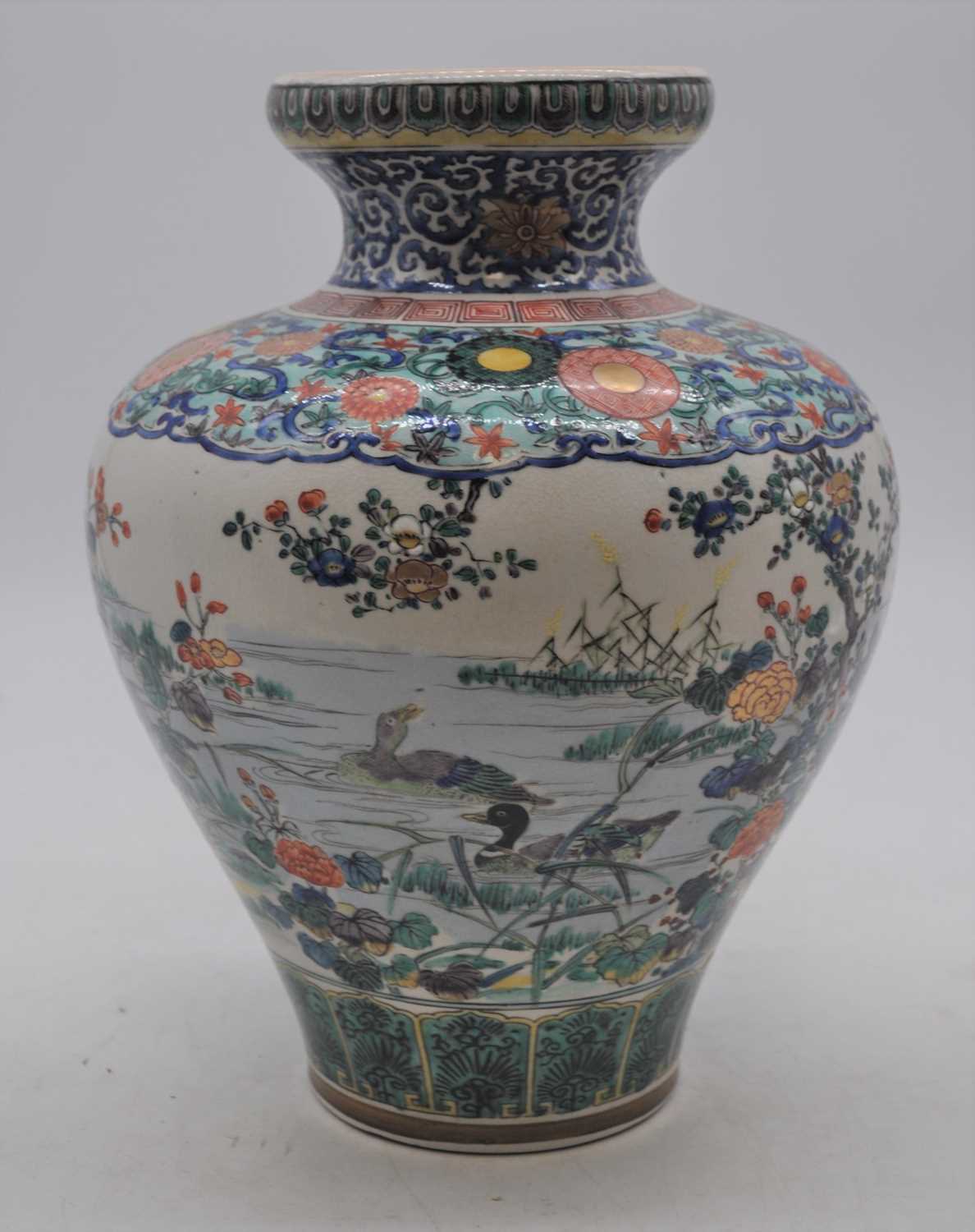 An early 20th century Japanese earthenware vase, enamel decorated with birds amongst flowers,