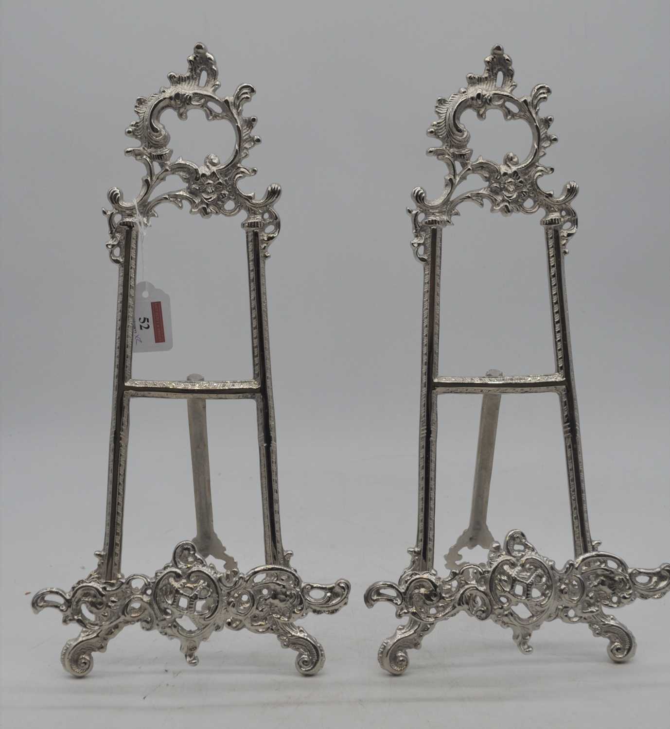 A pair of reproduction Rococo-style white metal plated table easels, each with Rockdale