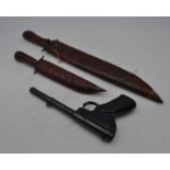 A Milbro Model 2 air pistol, together with two Indian daggers in decorative wooden sheaths (3)