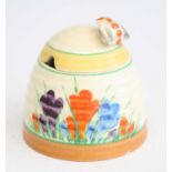 A 1930s Clarice Cliff Crocus pattern pottery honey-pot and cover, the cover with bee form finial, of