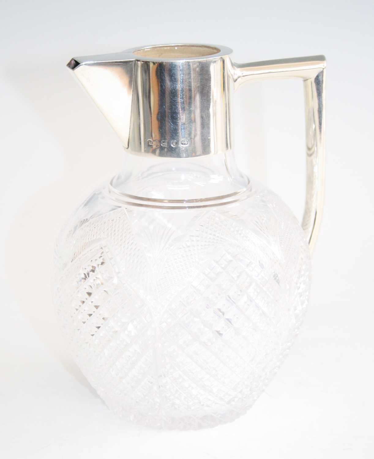An Art Nouveau silver mounted and cut crystal glass bodied claret jug, having an angular handle, the