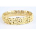 An 18ct yellow gold articulated link bracelet, set with twelve round brilliant cut diamonds, with