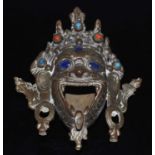 A copper alloy tripod incense burner, cast in the form of the head of Mahakala, having lapis